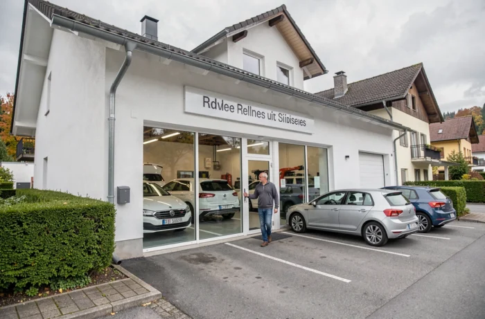 Façade extérieure d'un garage automobile professionnel en Suisse avec un client se dirigeant vers l'entrée